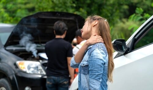Woman seated in car holds neck after apparent traffic collision